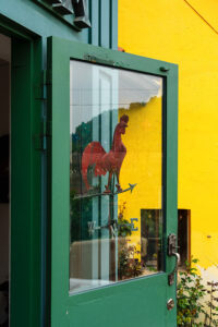 Rooster on the green door with yellow wall